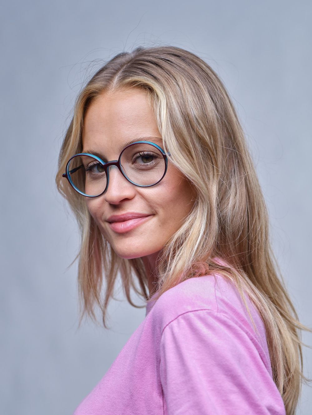 Zu sehen ist eine Frau mit einer runden Brille
