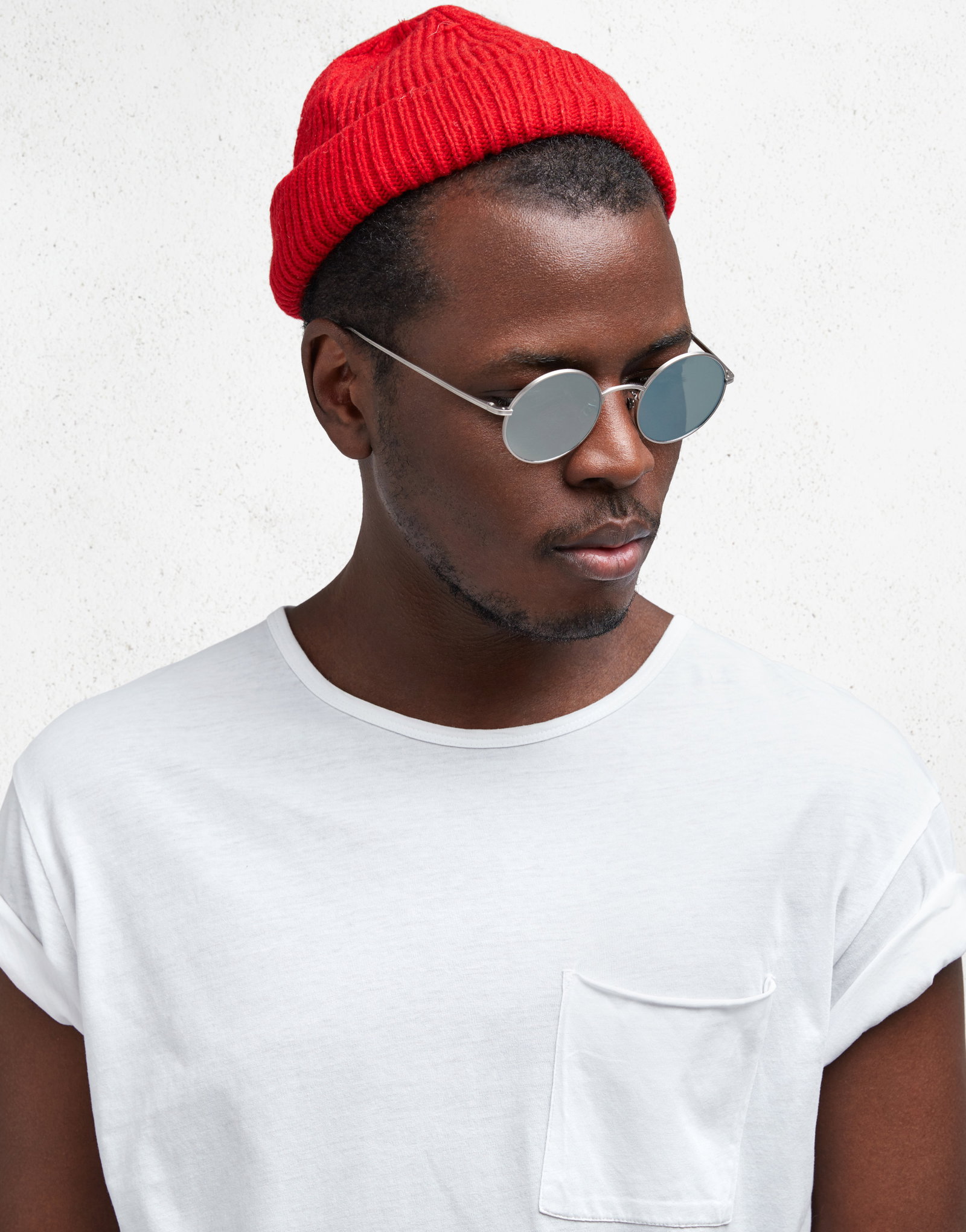 Das Bild zeigt einen Mann mit roter Mütze und runder Sonnenbrille.
